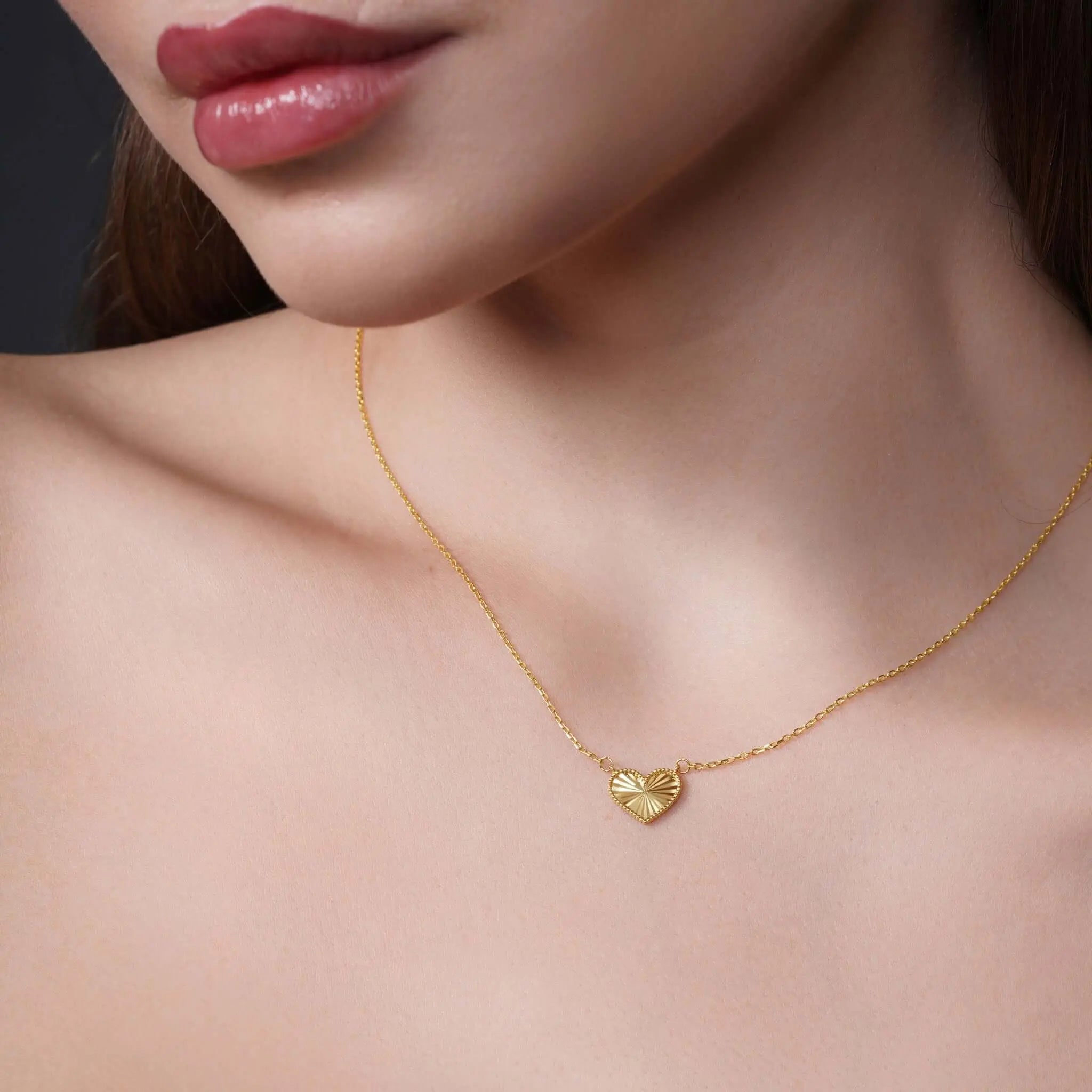 Gifts for her: a model showcasing a delicate gold heart necklace that embodies effortless elegance.