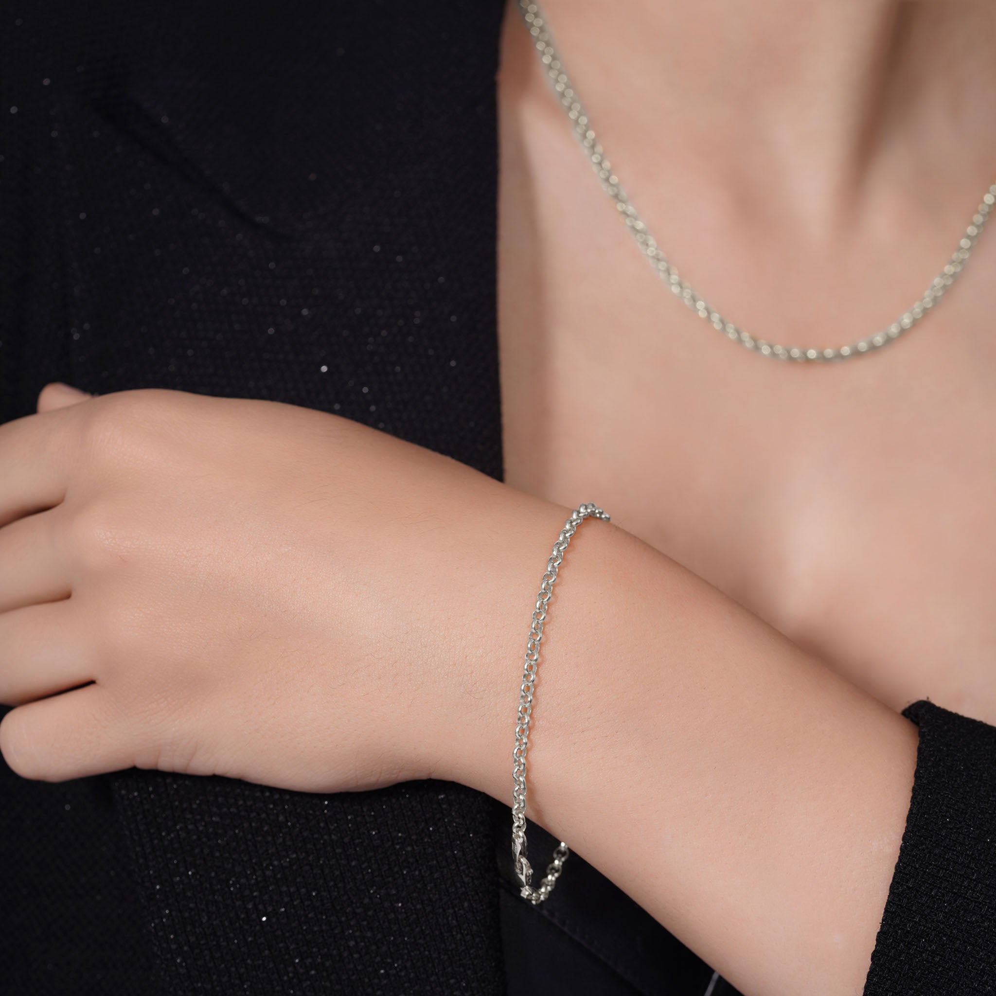 Silver Rolo Bracelet showcased on a model's wrist, featuring interlocking circular links with a polished finish.