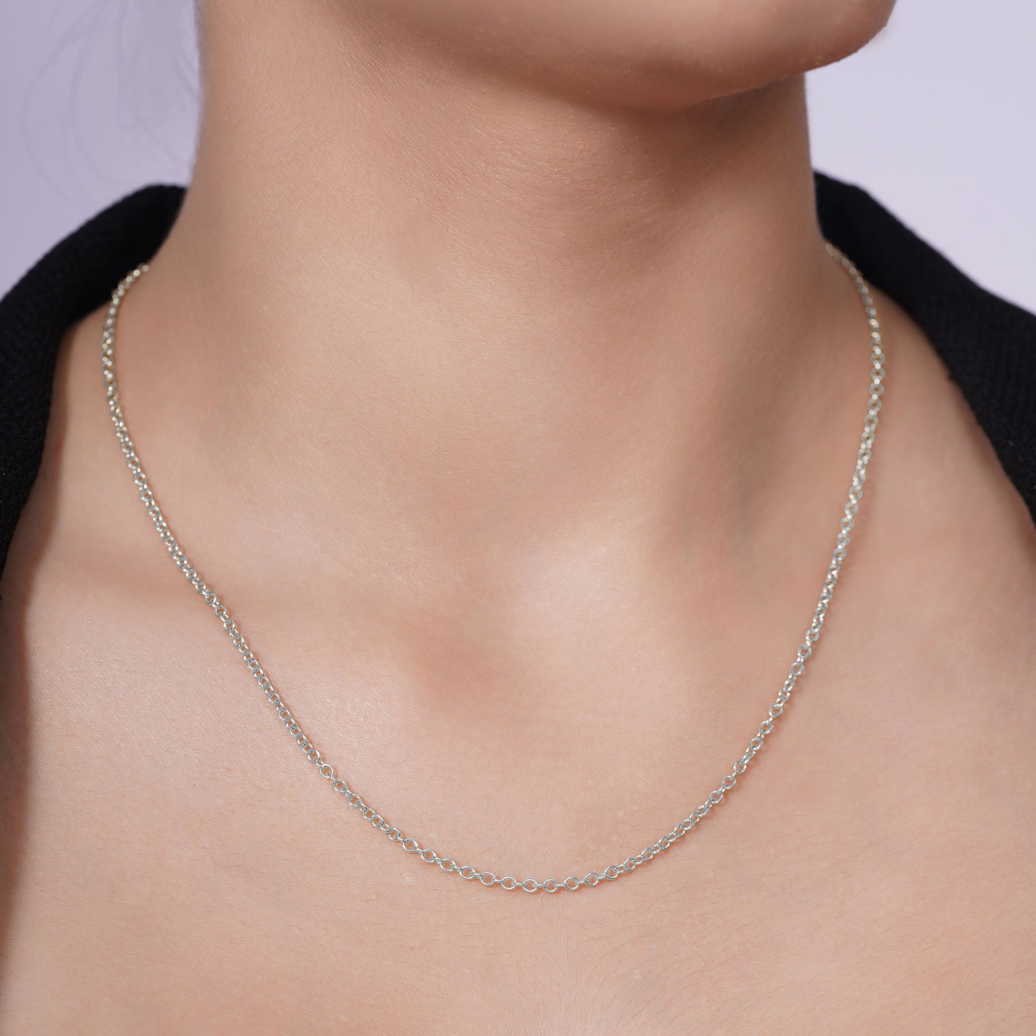 Silver Rolo Chain worn elegantly, showcasing its polished links and versatile design against a smooth neckline.