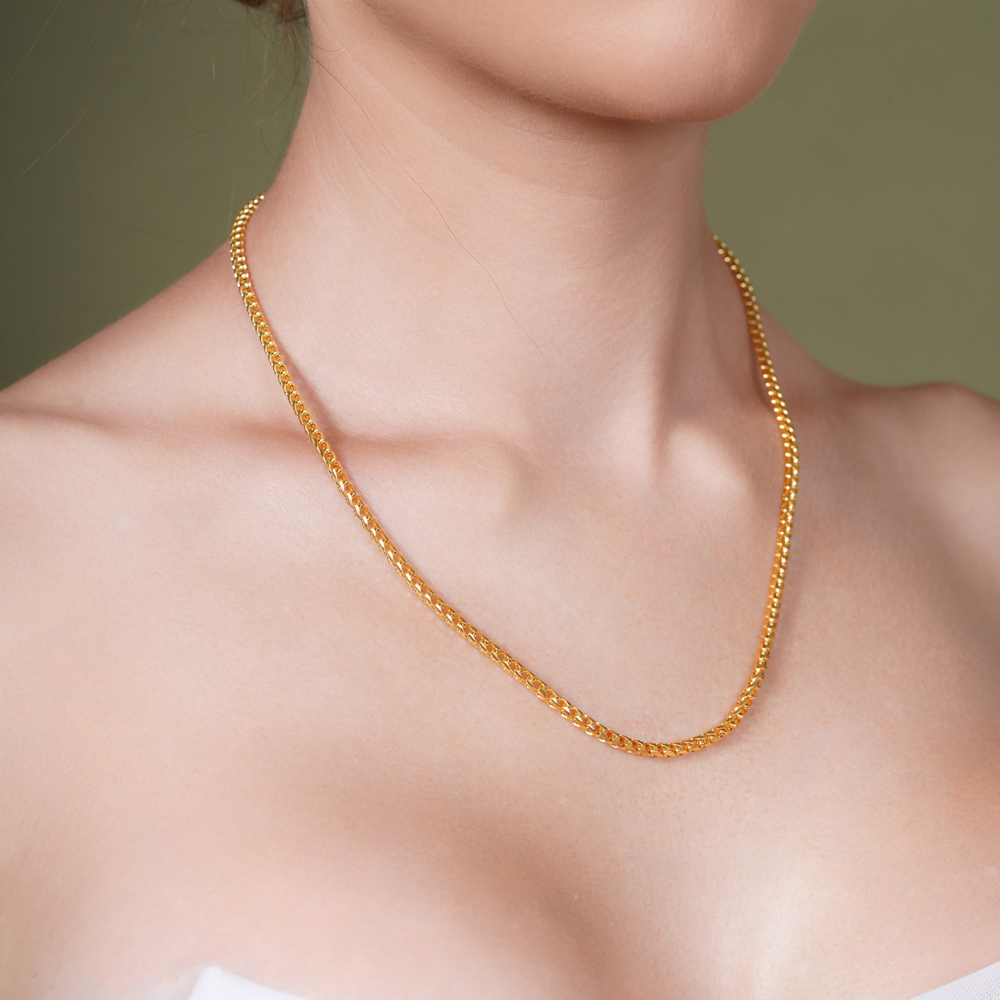 Diamond Cut Franco Vermeil Gold Chain displayed on a model's neck, showcasing its elegant design and luxurious shine.
