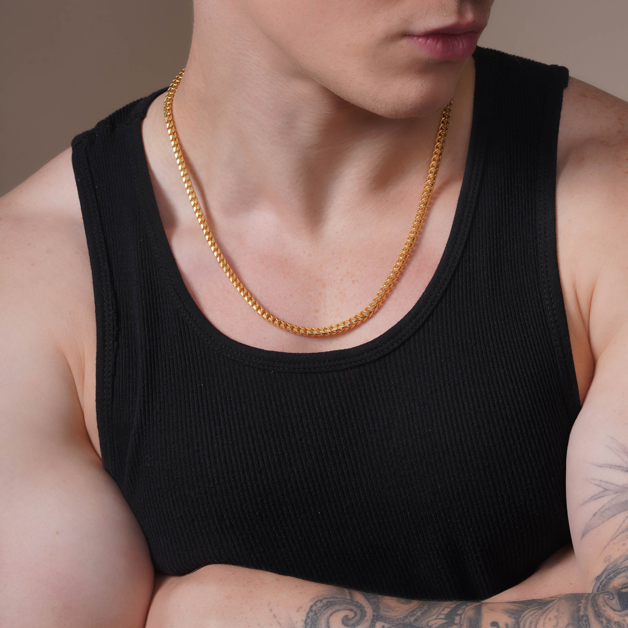 Close-up of a man wearing a Men's Franco 18K Gold Vermeil Chain with a black tank top and arms crossed.
