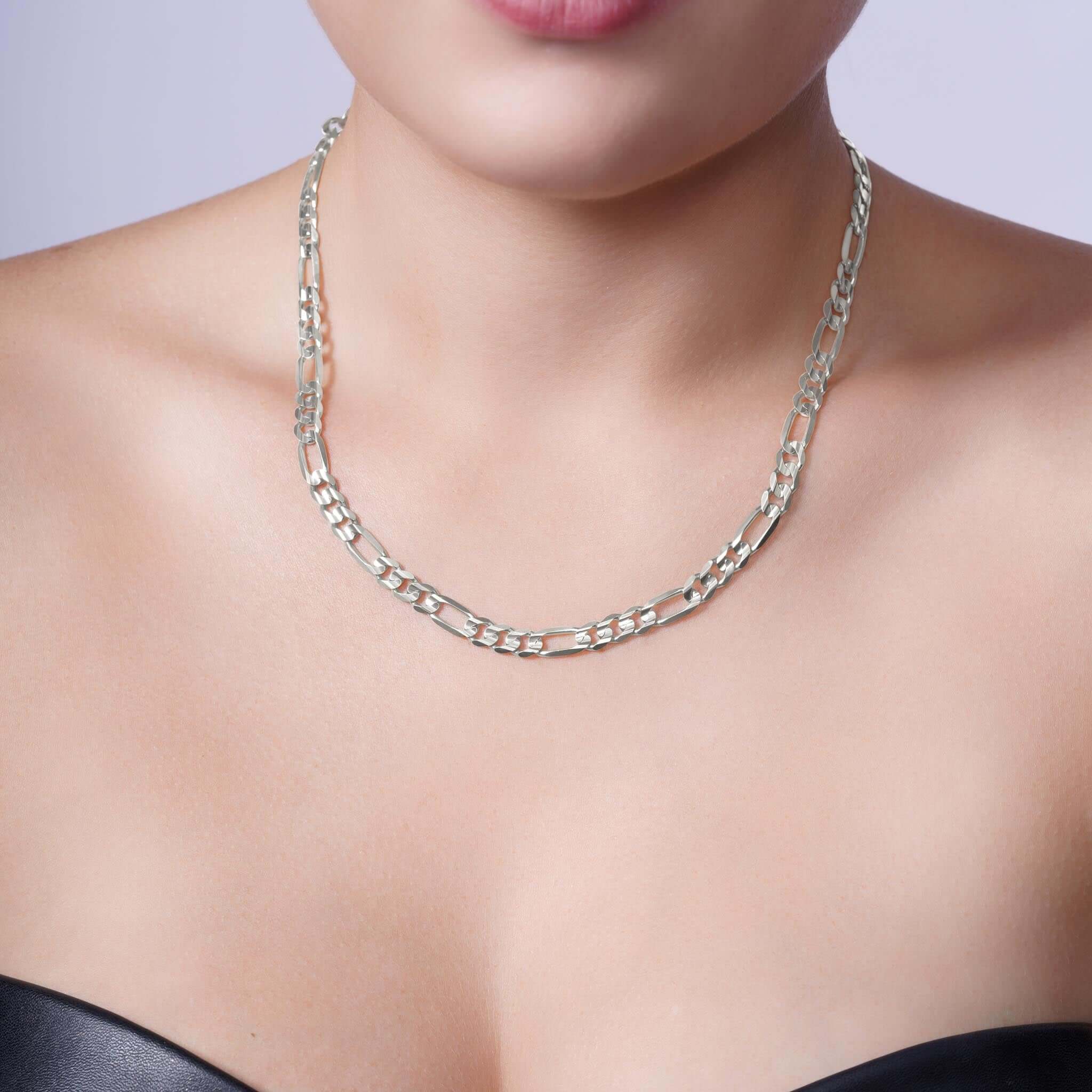 Woman wearing a Figaro Silver Chain necklace showcasing its elegant design and lustrous finish.