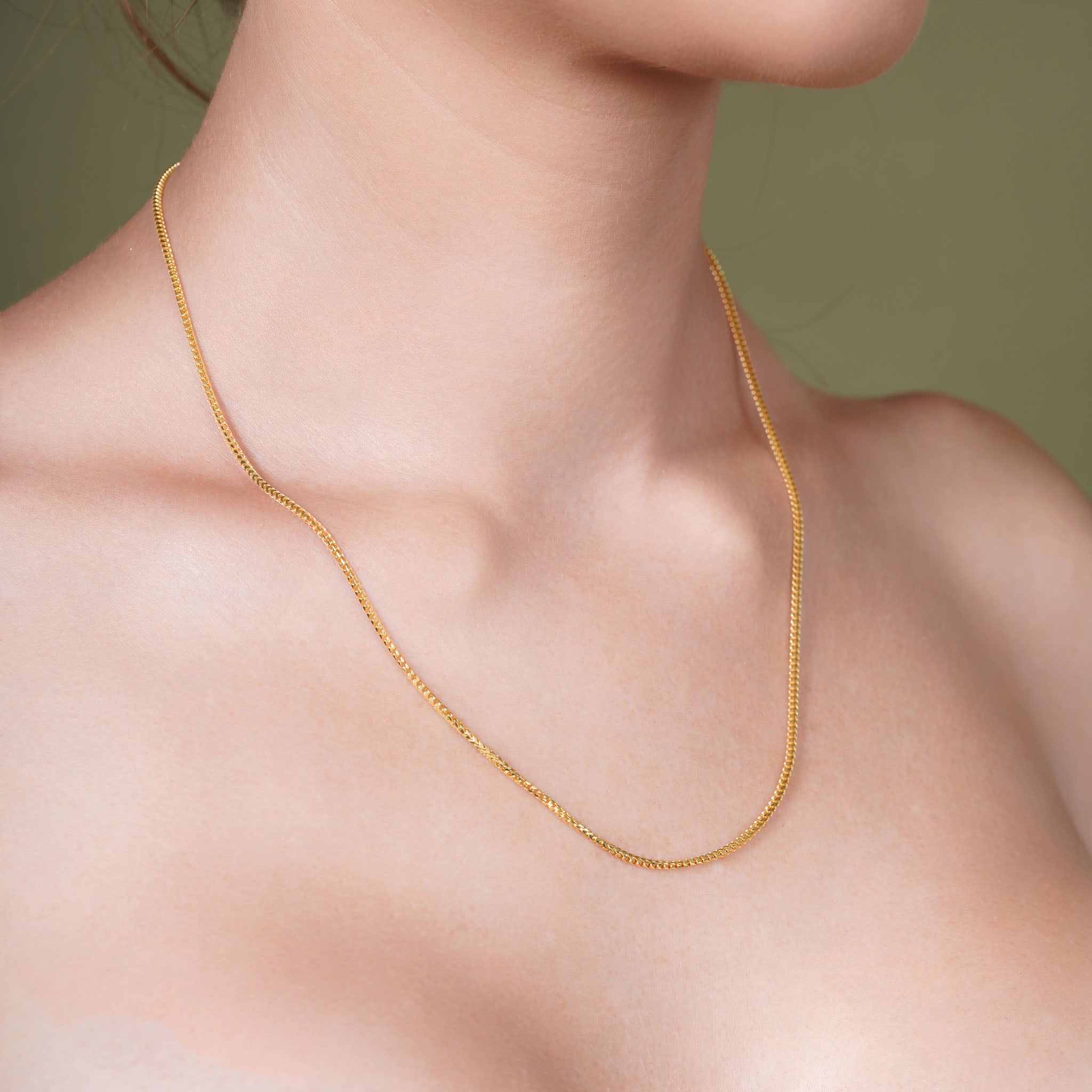 18K Gold Vermeil Franco Chain displayed on a model's neck, showcasing luxury and elegance.