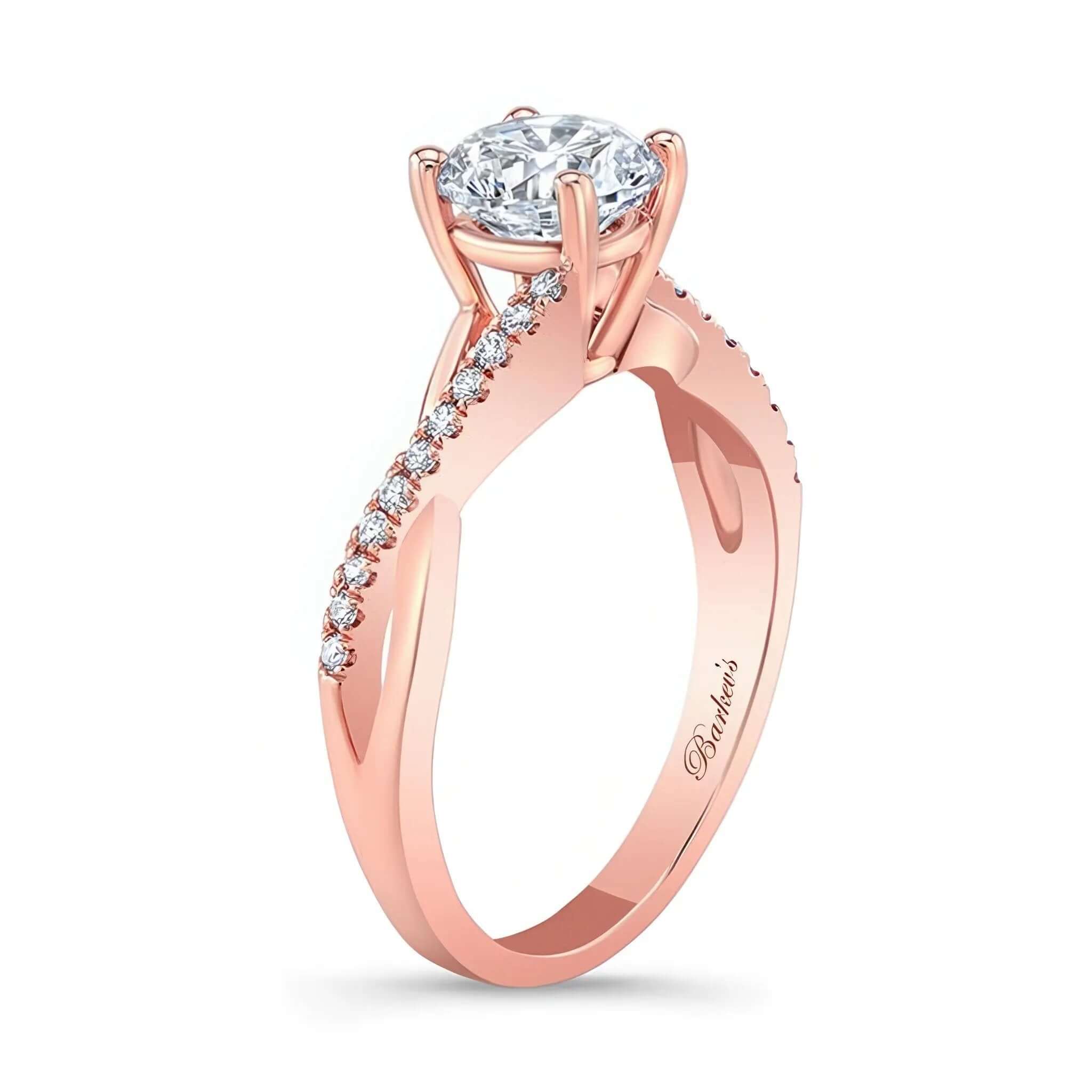 Simple Diamond Ring featuring a prong set round center and intertwining shoulders with diamond melees.