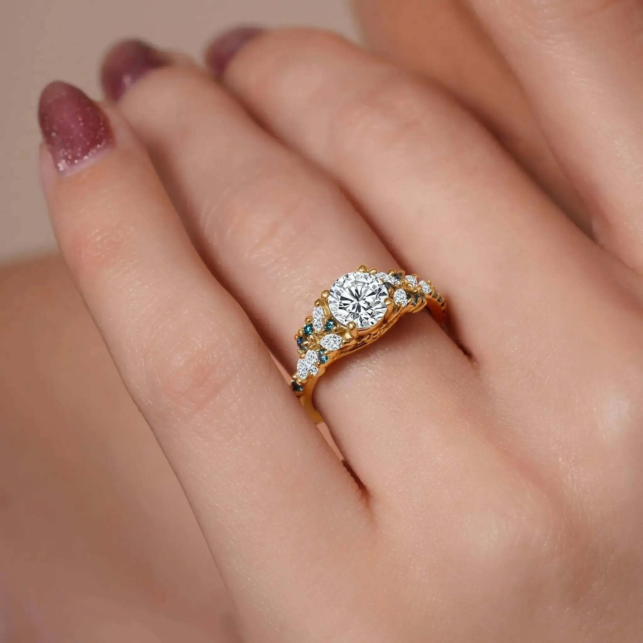 Vintage Marquise Blue Diamond Accent Engagement Ring shown on a hand with a prong set round center and blue diamond accents.