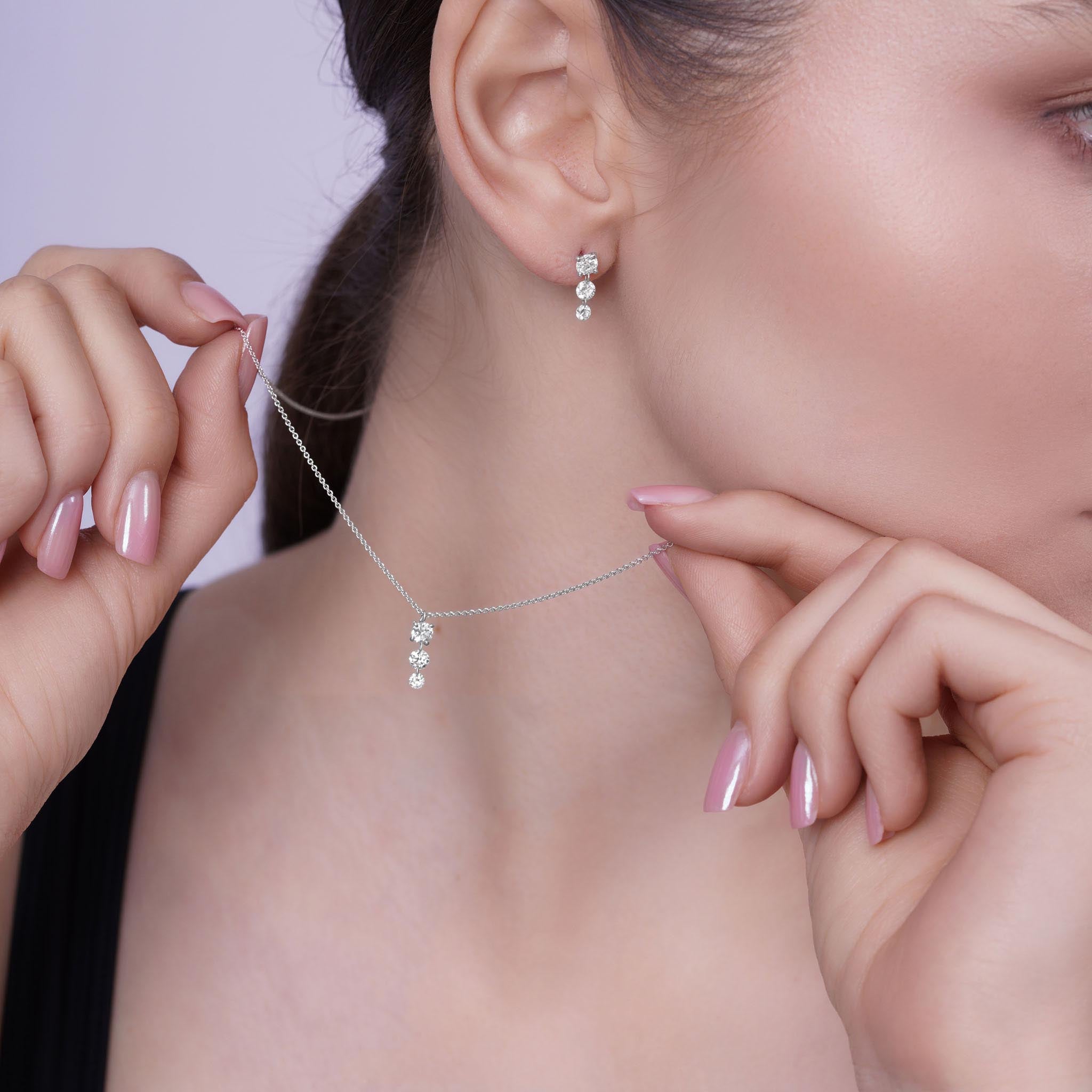 Floating Three-Stone Lab Diamond Pendant Necklace showcased with matching earrings on model's profile.