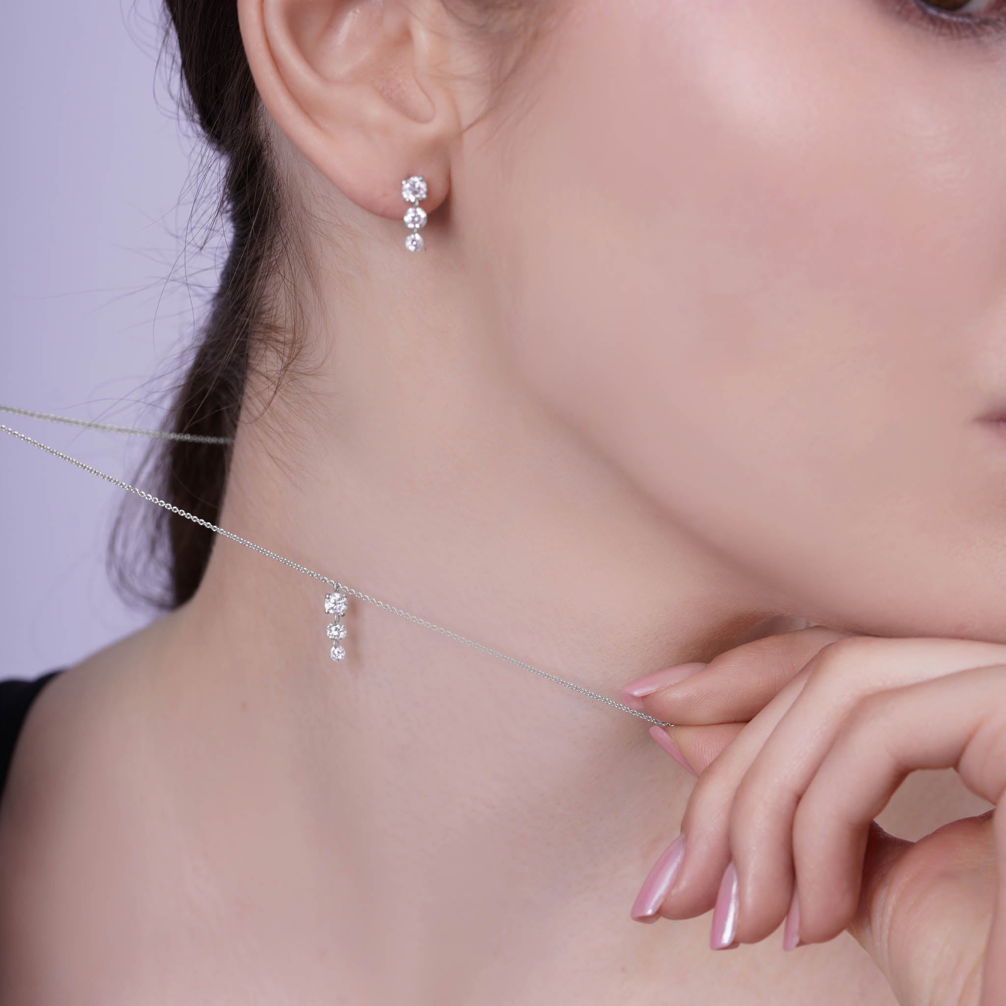 Floating Three-Stone Lab Diamond Pendant Necklace worn elegantly next to matching earrings, showcasing a refined style.