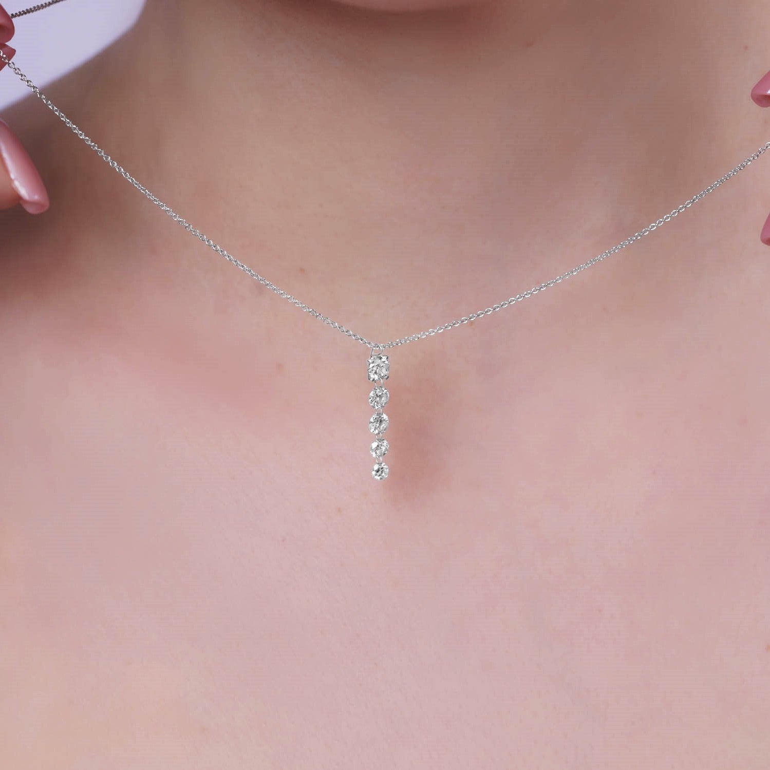 Floating Five-Stone Lab Diamond Pendant Necklace displayed on a model's neck, featuring five graduated diamonds in a sleek design.