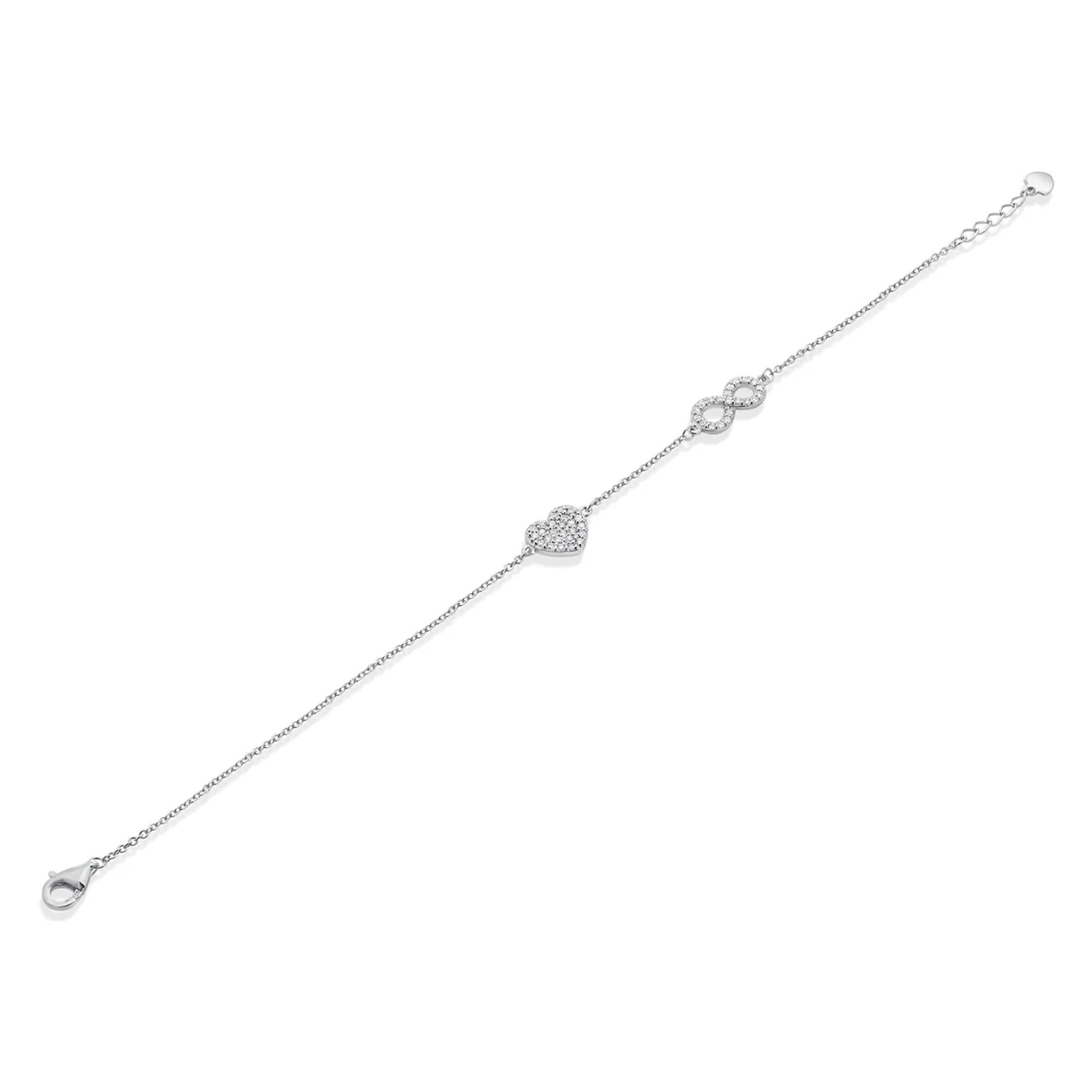 A delicate silver chain bracelet featuring a heart-shaped and infinity symbol charms, each adorned with tiny clear diamonds, displayed diagonally on a solid white background.