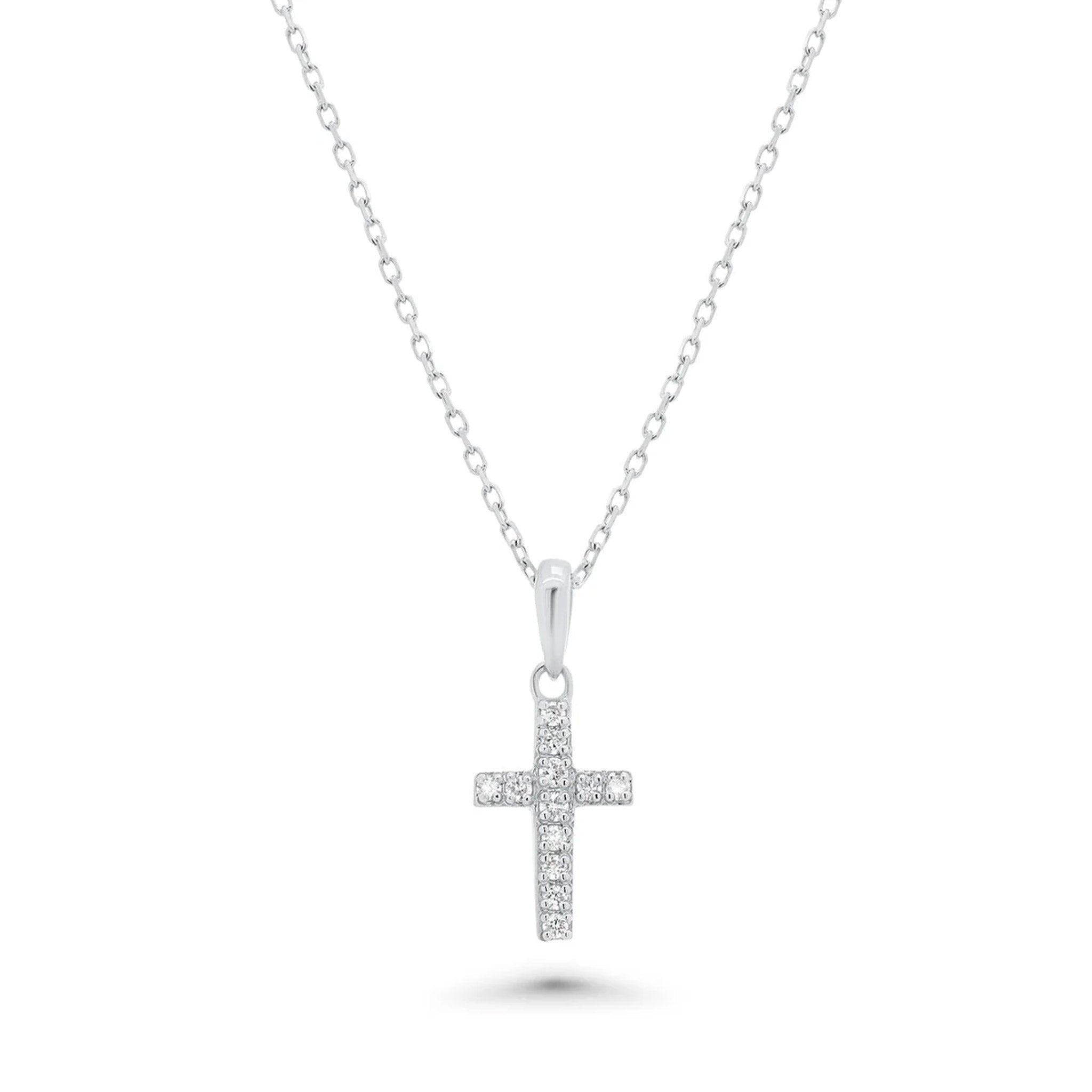 A silver cross pendant necklace adorned with small diamonds stones, suspended from a delicate silver chain against a plain white background.