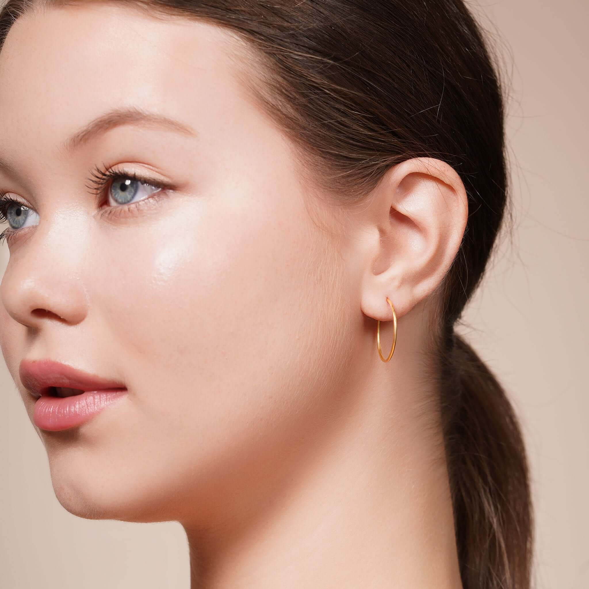 Model wearing Gold Endless Hoop Earrings showcasing their timeless design and elegance.