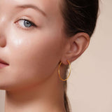 Close-up of a woman wearing Gold Endless Hoop Earrings, showcasing their elegant and timeless design.