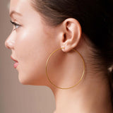 Gold Endless Hoop Earrings worn by a model, showcasing their elegant design and timeless appeal.