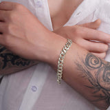Men's solid gold curb bracelet worn on a wrist, showcasing its elegant design and durable craftsmanship.