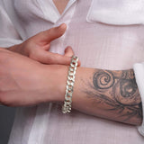 Men's solid gold curb bracelet worn on wrist, showcasing its elegant design and craftsmanship.