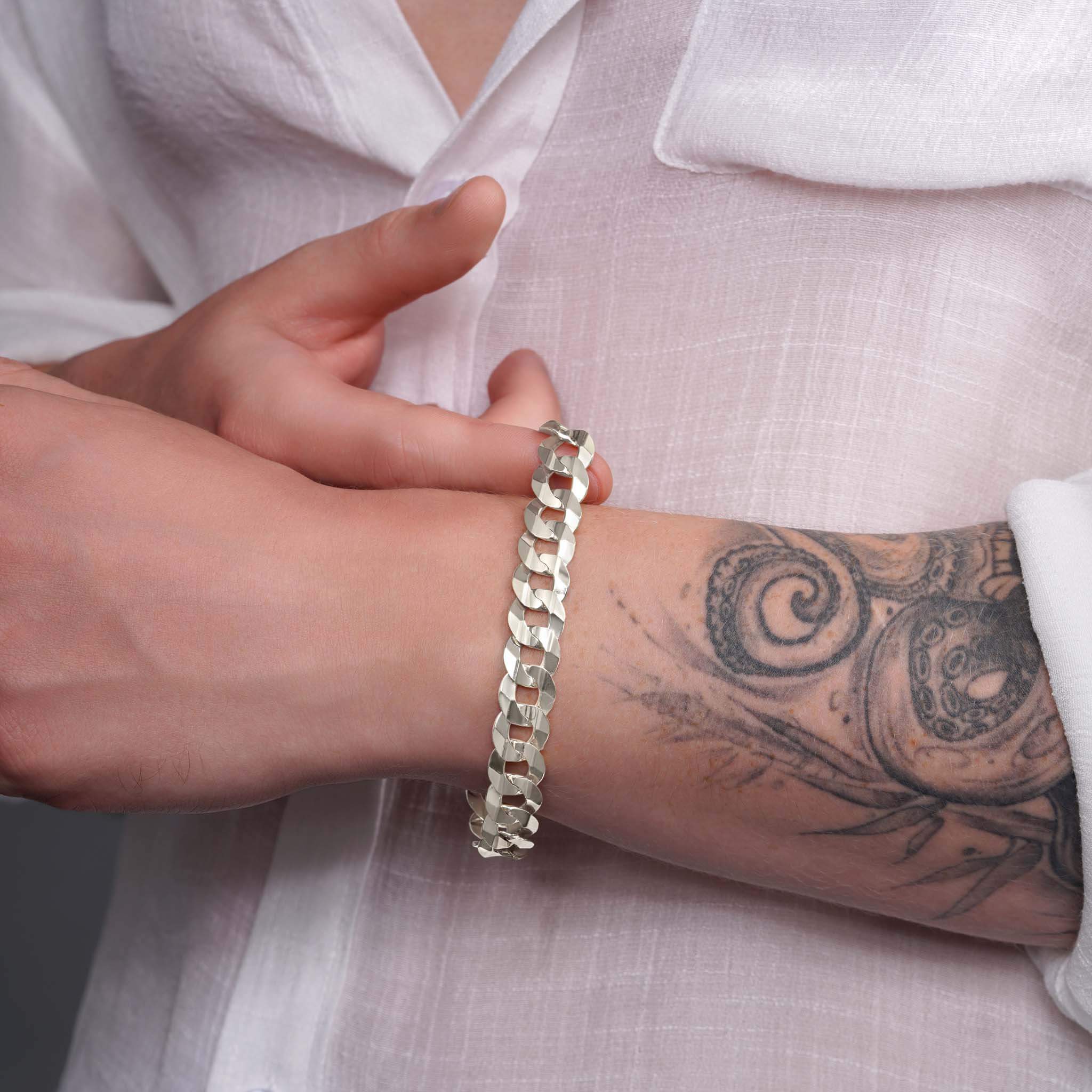 Men's solid gold curb bracelet worn on wrist, showcasing its elegant design and craftsmanship.
