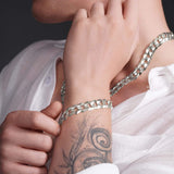 Stylish man wearing a solid gold curb bracelet and necklace, showcasing a bold and refined look.