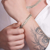 Men's solid gold curb bracelet on a wrist, showcasing a classic design and craftsmanship.