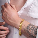 Men's solid gold curb bracelet on a wrist, featuring a classic design and durable craftsmanship.