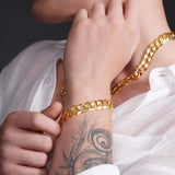 Close-up of a model wearing a men's solid gold curb bracelet, showcasing the elegant design and craftsmanship.