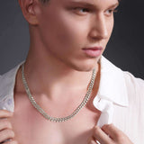 Close-up of a man wearing a sleek 14k solid gold curb chain necklace, showcasing its elegant design and shine.