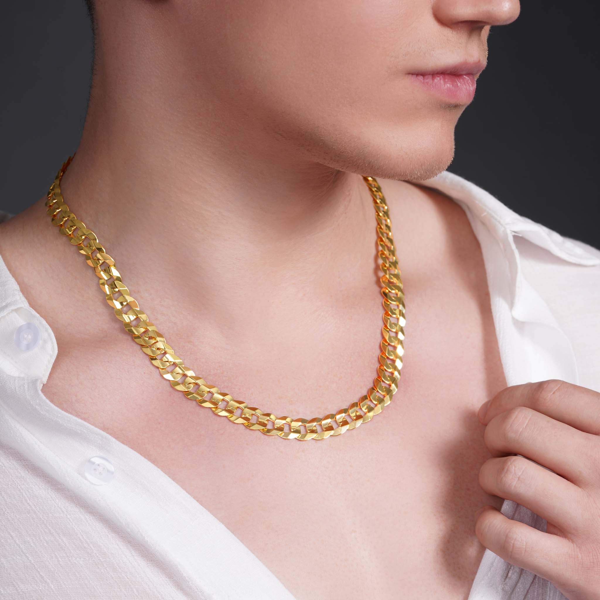 Men's solid gold curb chain worn by a model, reflecting light and showcasing the iconic design.