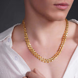 Men's solid gold curb chain necklace worn by a male model, showcasing its shiny interlocking links.