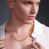 Stylish young man wearing a Men's Solid Gold Curb Chain necklace in 14k gold, highlighting its elegant design.
