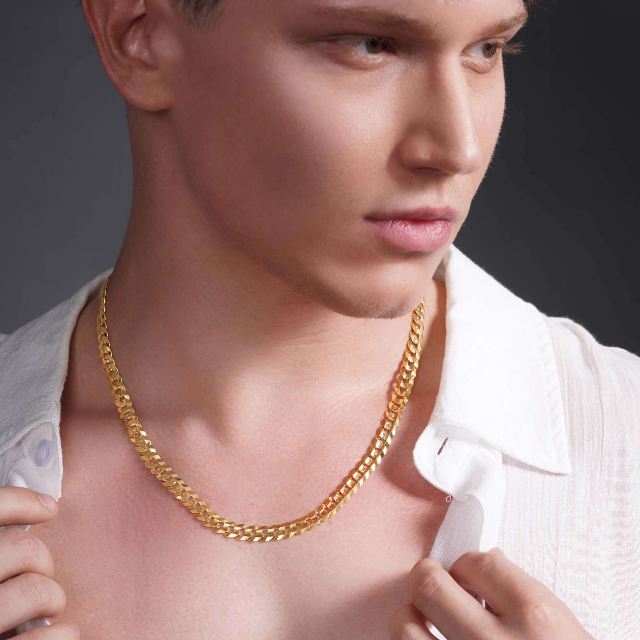 Stylish young man wearing a Men's Solid Gold Curb Chain necklace in 14k gold, highlighting its elegant design.