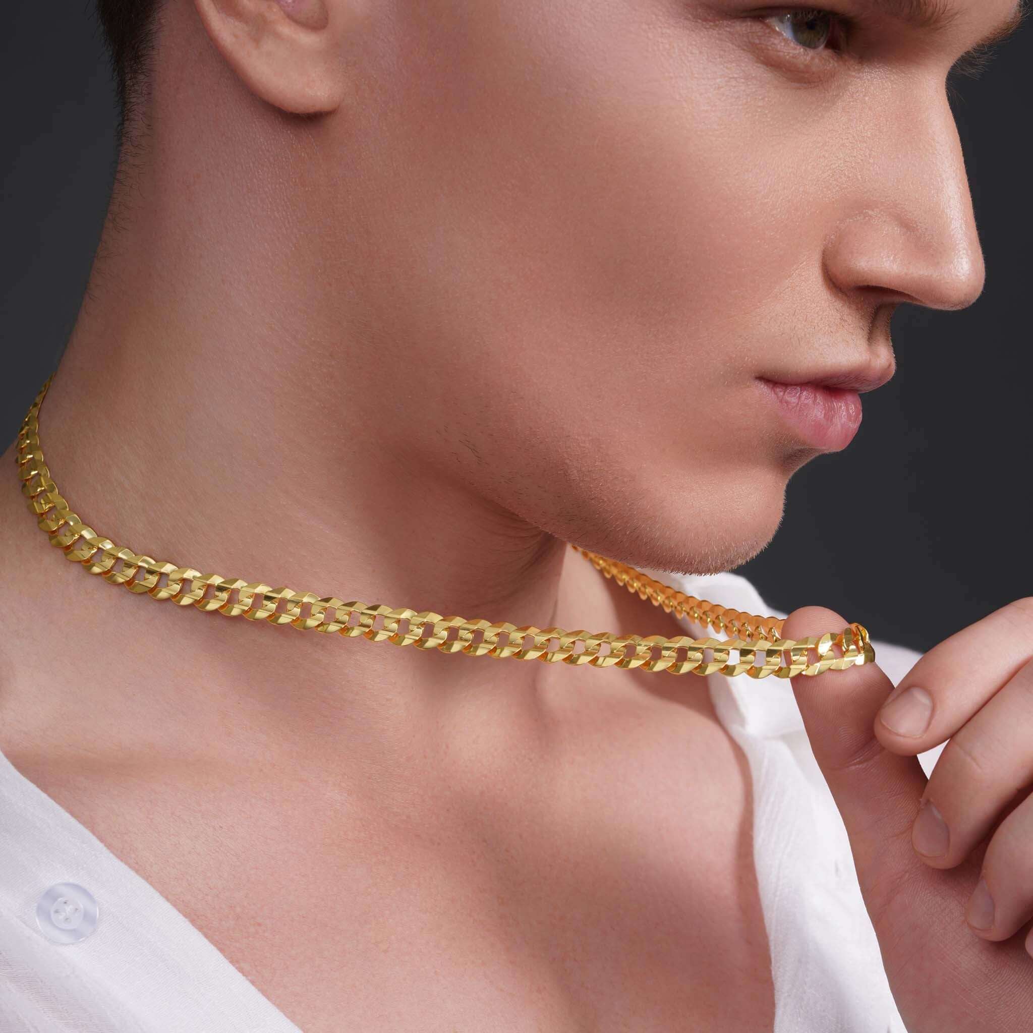Close-up of a man wearing a Men's Solid Gold Curb Chain, showcasing its shiny yellow gold links.
