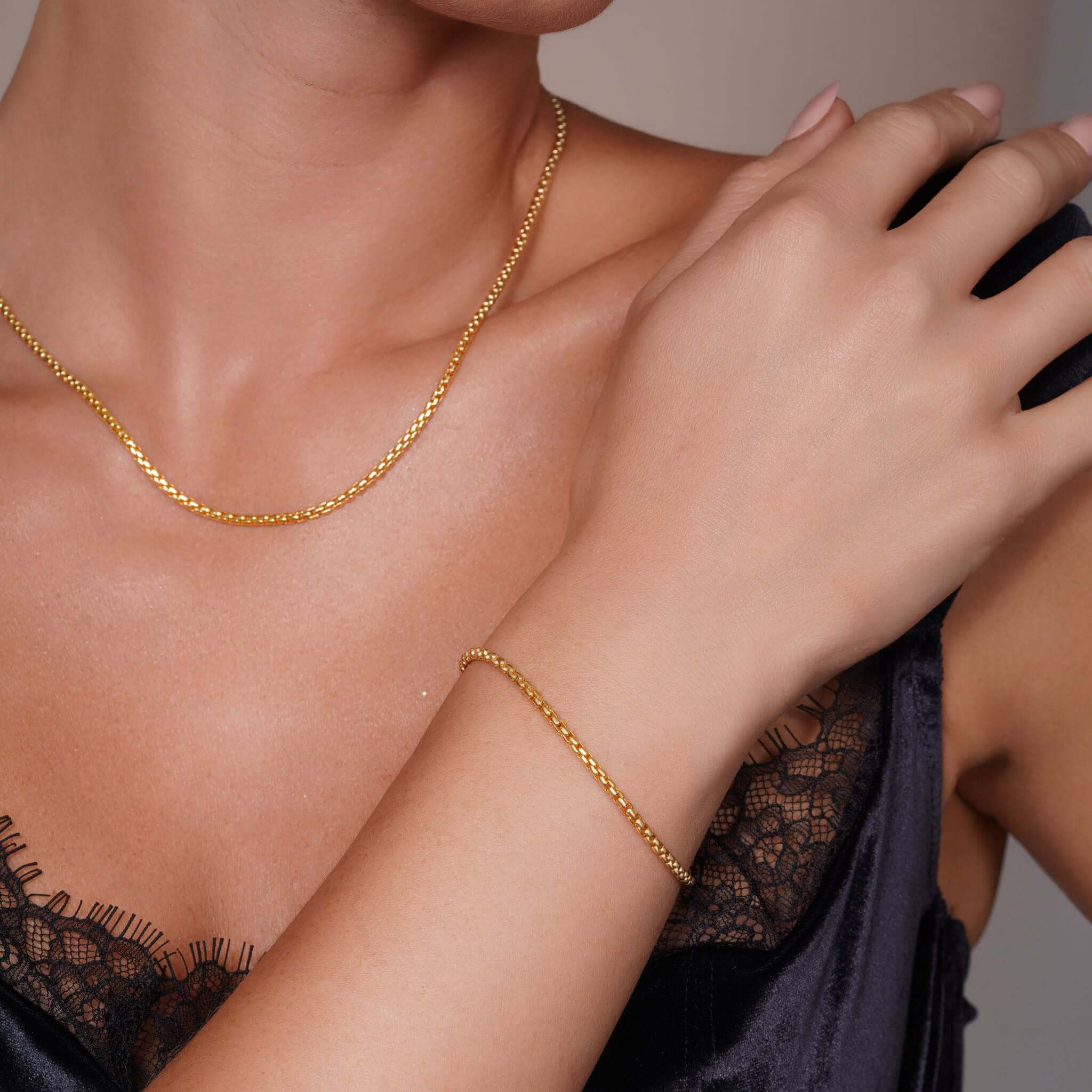 Elegant model wearing a Round Box Chain Bracelet in 14k yellow gold, showcasing its sleek design and comfort.