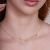 14k Gold Triple Heart Station Necklace worn by a model, featuring three delicate open-heart stations on a fine chain.