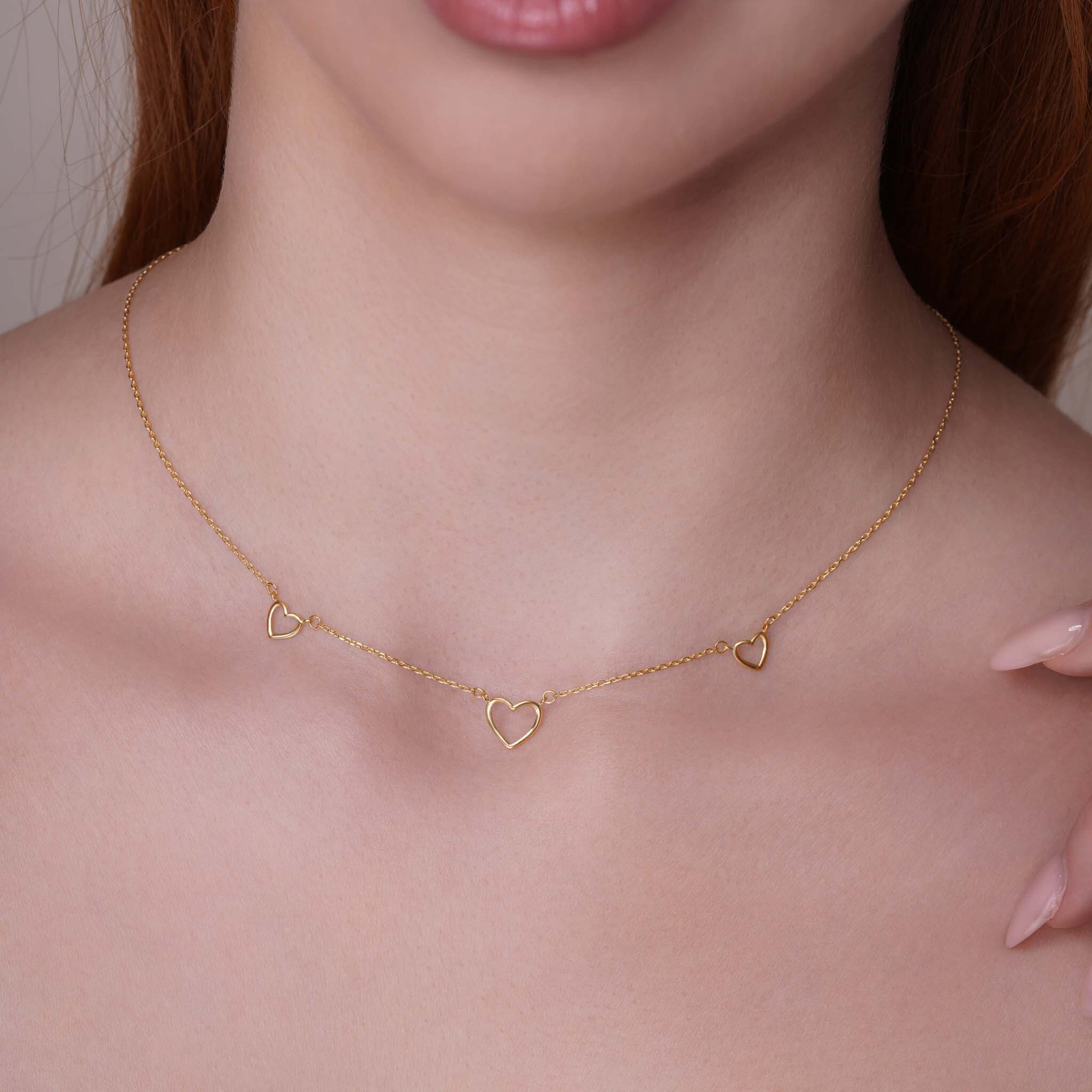 14k Gold Triple Heart Station Necklace showcasing delicate heart stations on a fine gold chain.