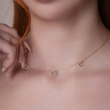 14k Gold Triple Heart Station Necklace worn by a model showcasing the delicate design and adjustable length.
