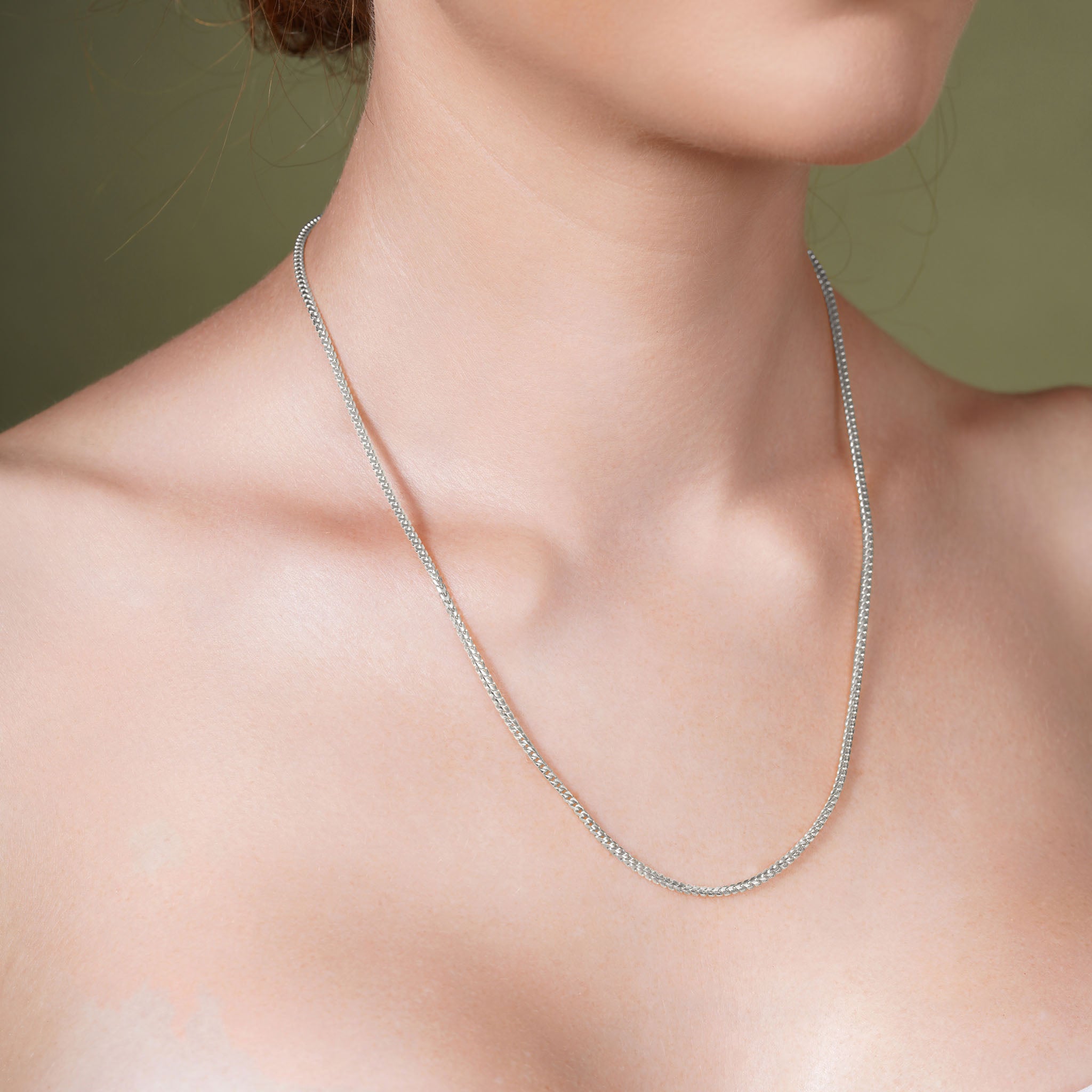 Franco Silver Chain displayed elegantly on a model's neck, showcasing its smooth polished finish and distinctive design.