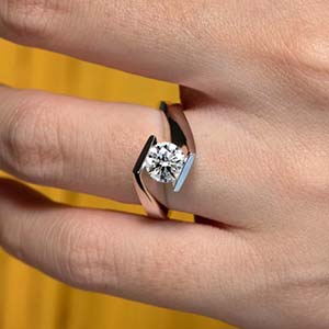 Unique solitaire diamond engagement ring on a hand